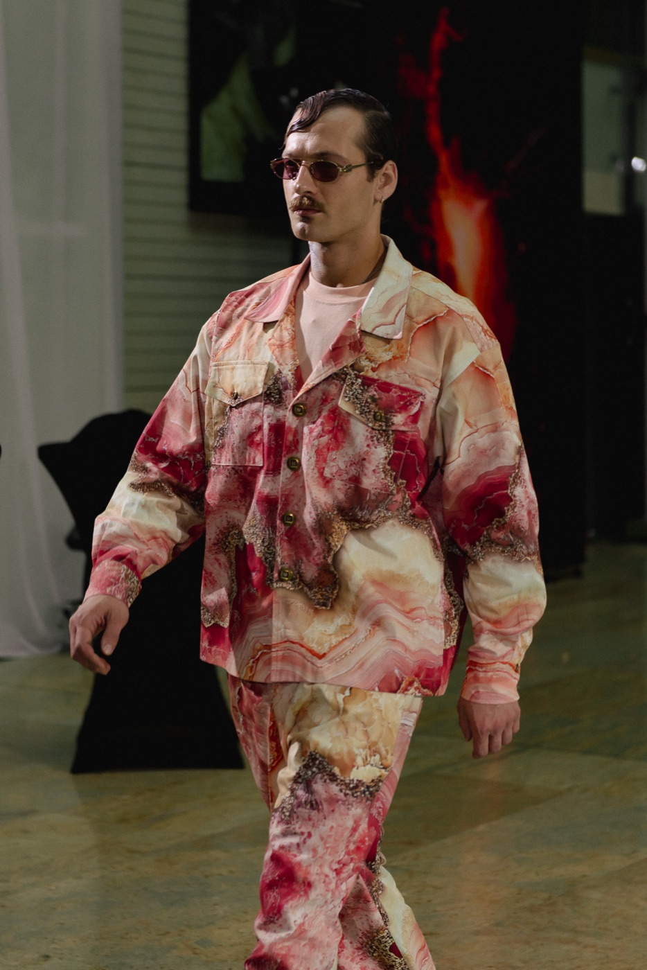 Akasha runway, marble-print suit against red light