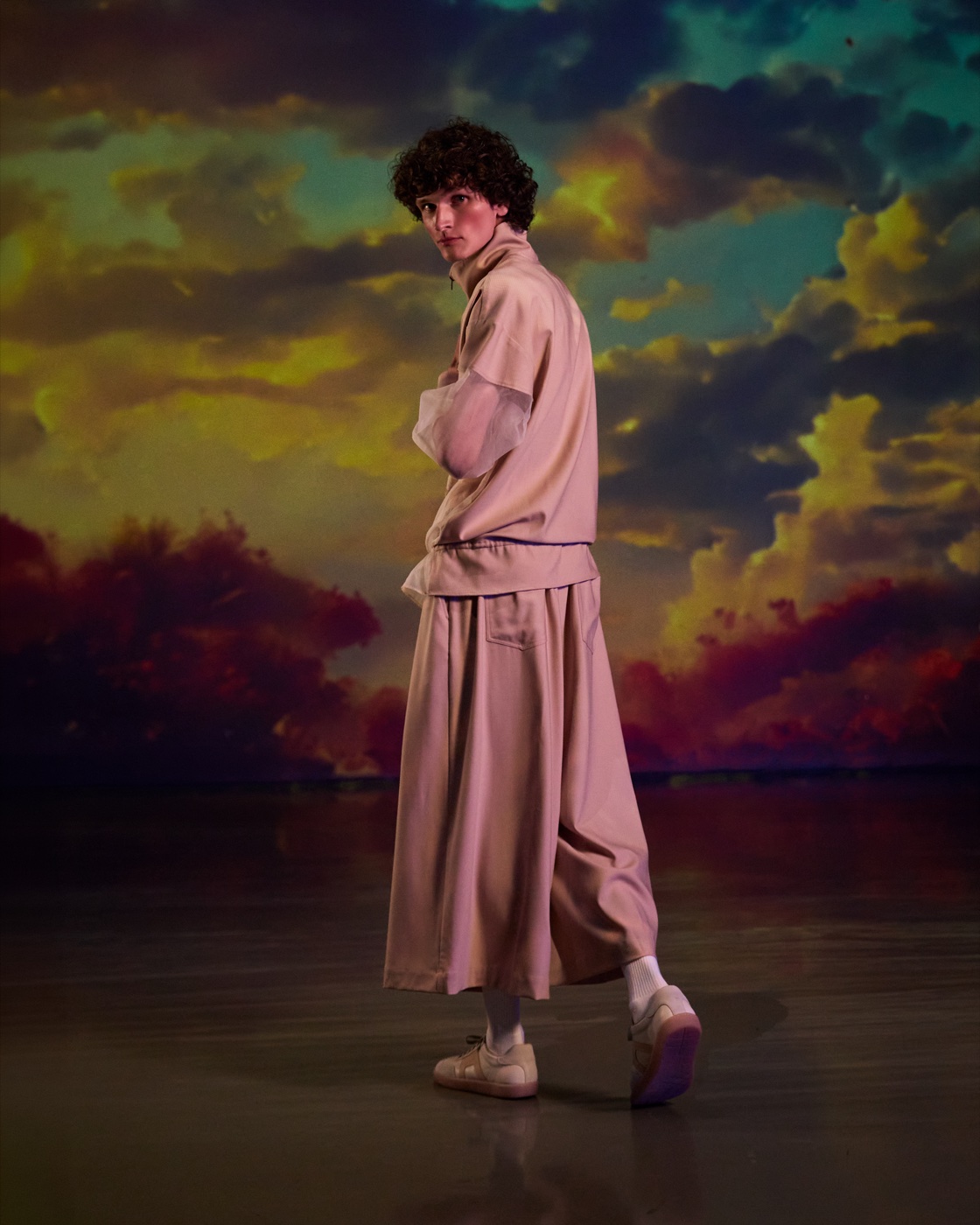 Origin campaign, beige skirt set against sunset sky, back view