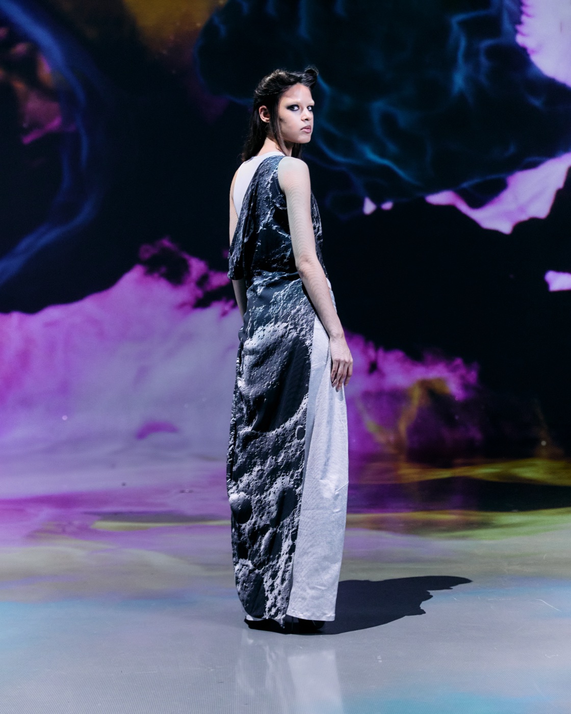 Origin campaign, moon-textured gown against nebula, back view