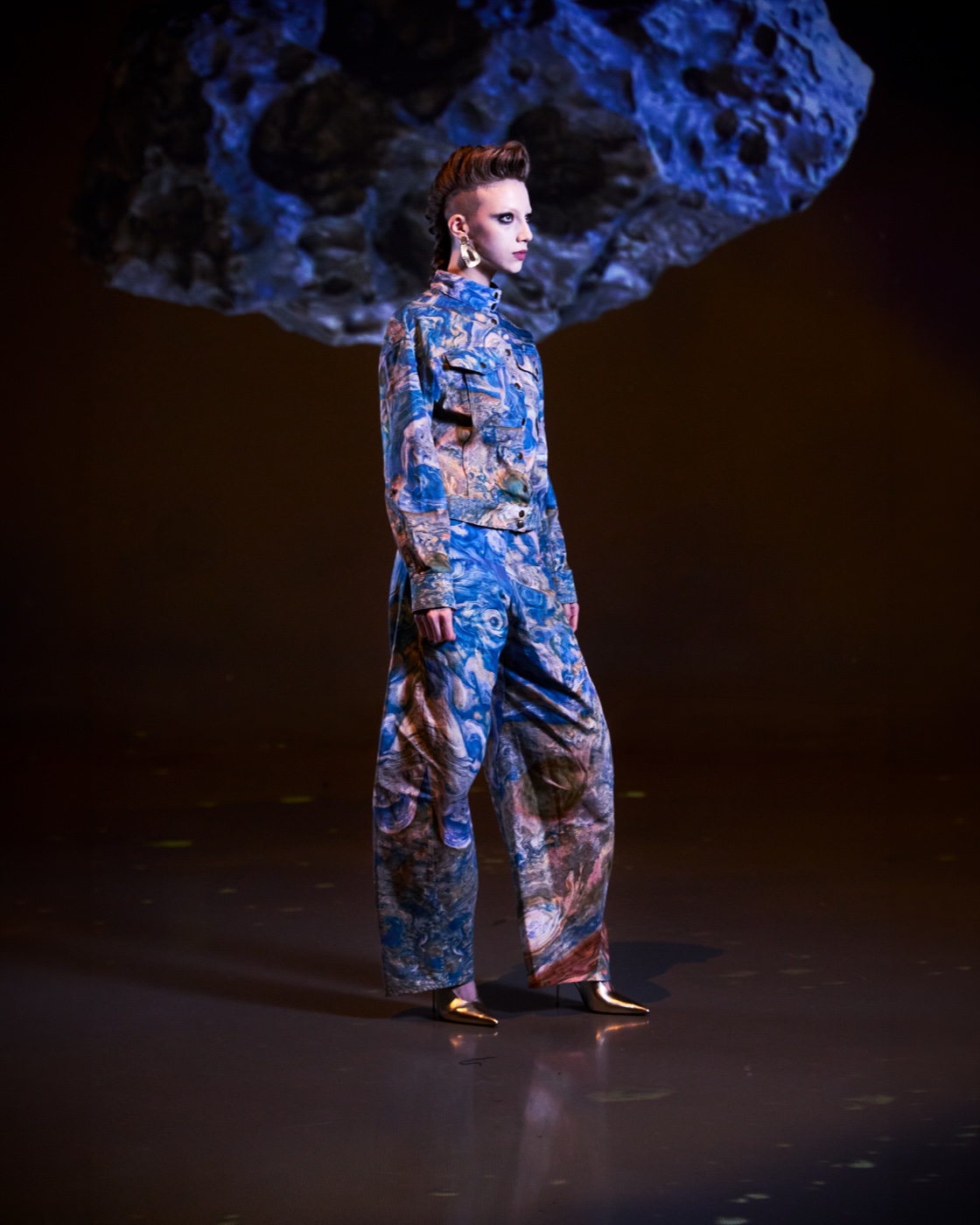 Origin campaign, blue paisley jumpsuit against floating rock